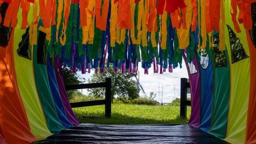 A colourful play tunnel with Horsey Windpump visible in the distance..